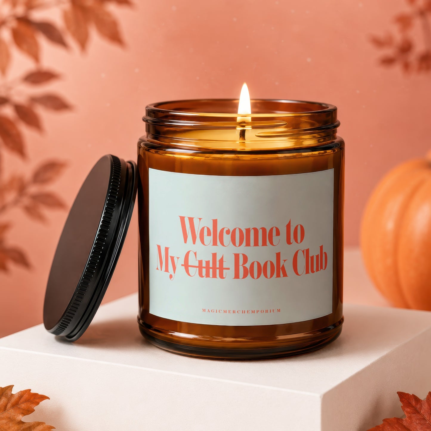 Candle with "Welcome to My Cult-Book Club" text and fall decor.