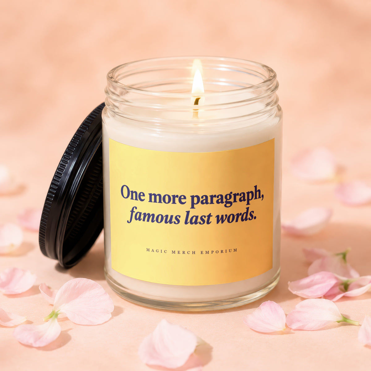 Glass candle with lit flame and label that reads "One more paragraph, famous last words."