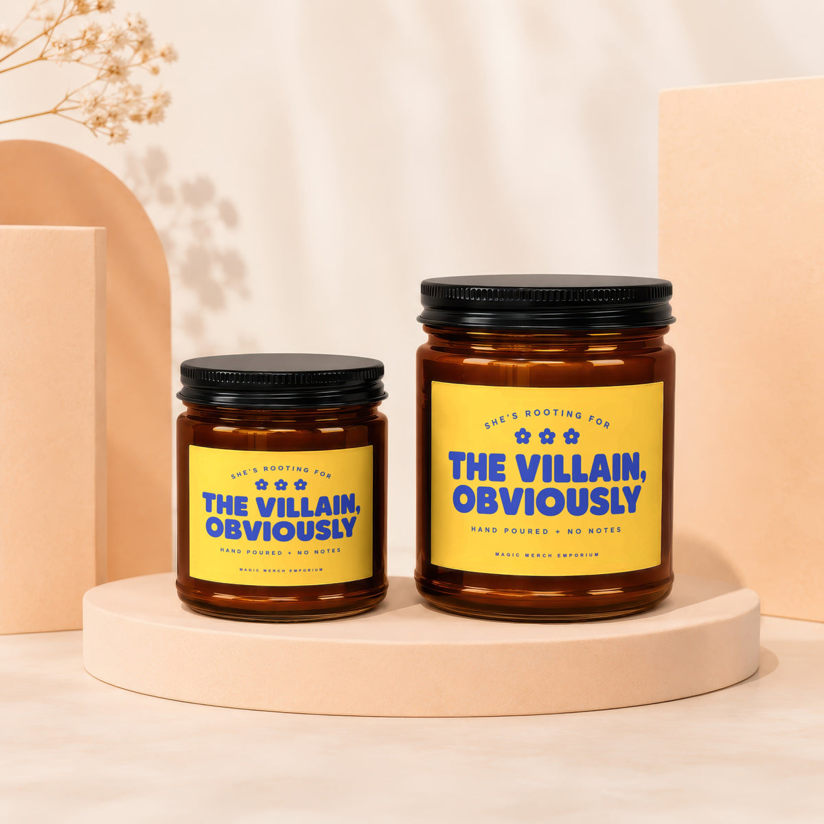 Two amber glass candles with yellow labels that say "The Villain, Obviously".