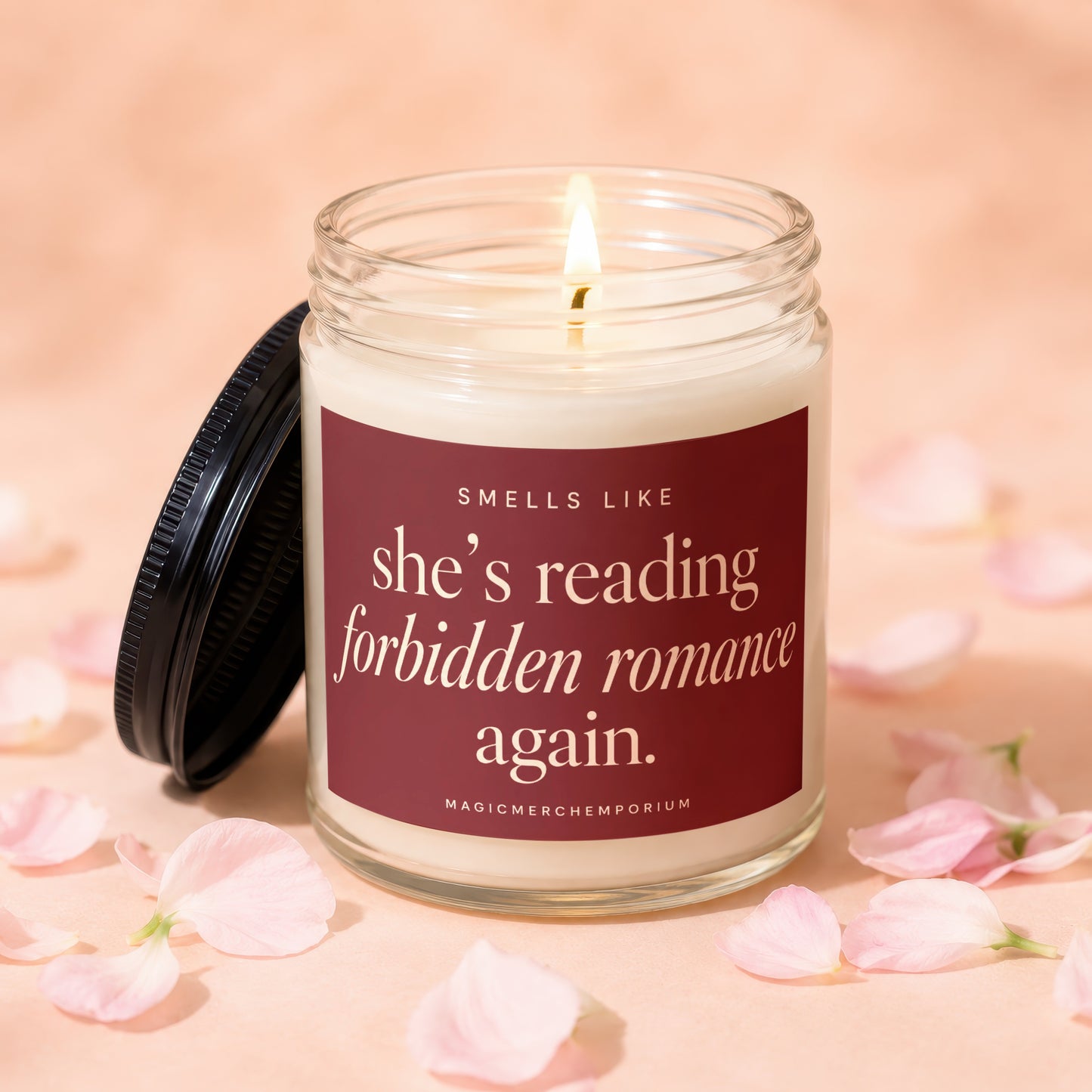 Candle with "she's reading forbidden romance again." text, surrounded by pink petals.