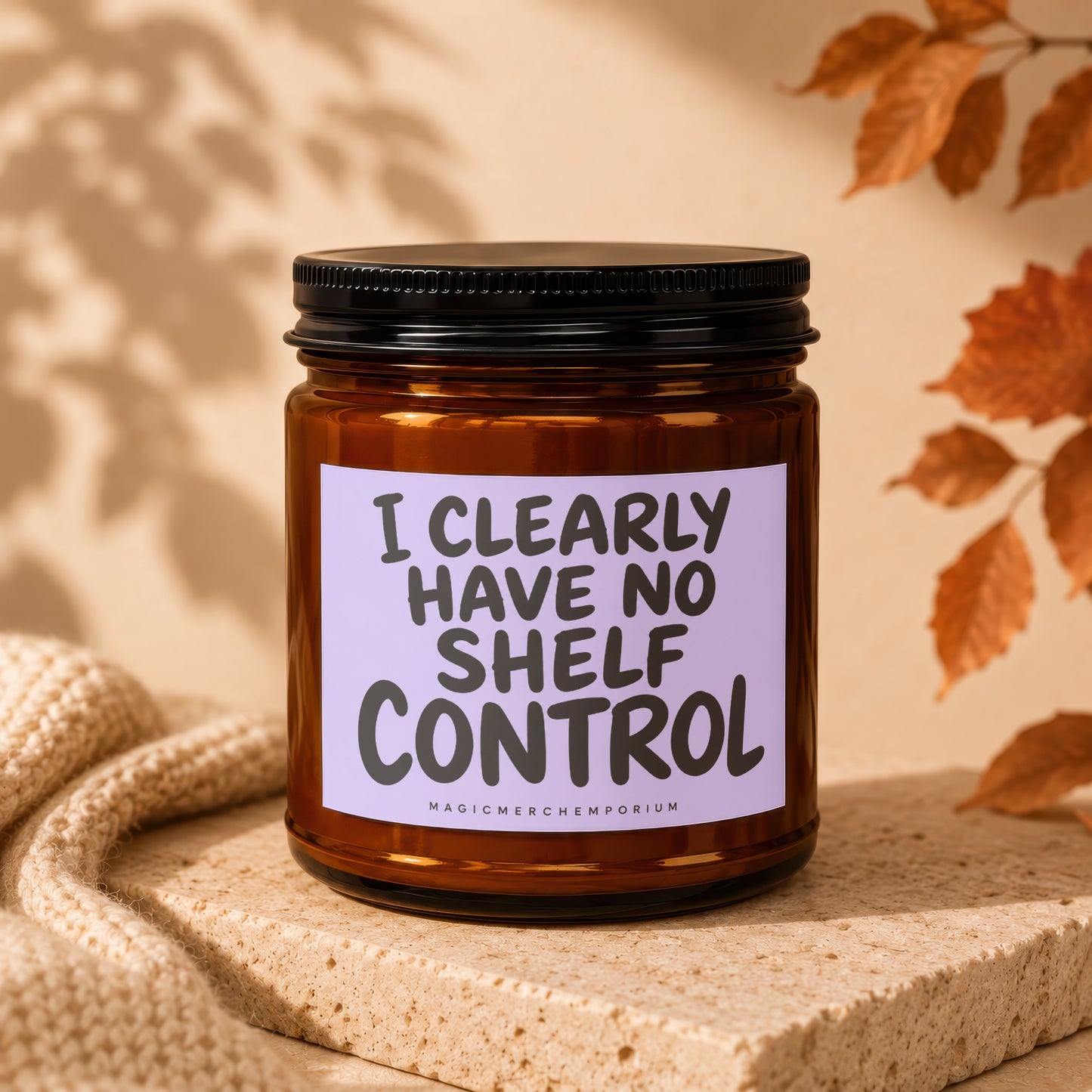 Amber candle with black lid and lavender label saying "I CLEARLY HAVE NO SHELF CONTROL".