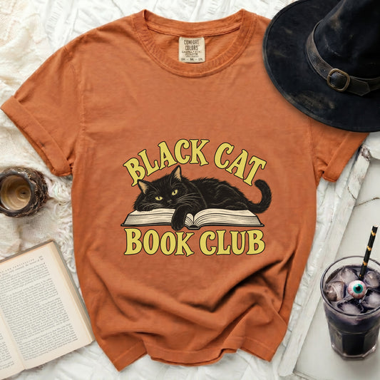 Orange t-shirt with a black cat on an open book, text reads "Black Cat Book Club".