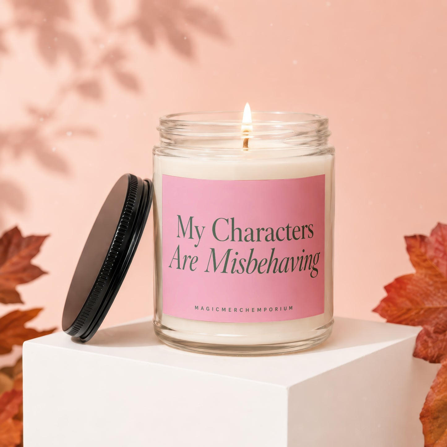 Candle with "My Characters Are Misbehaving" text on a pink label.