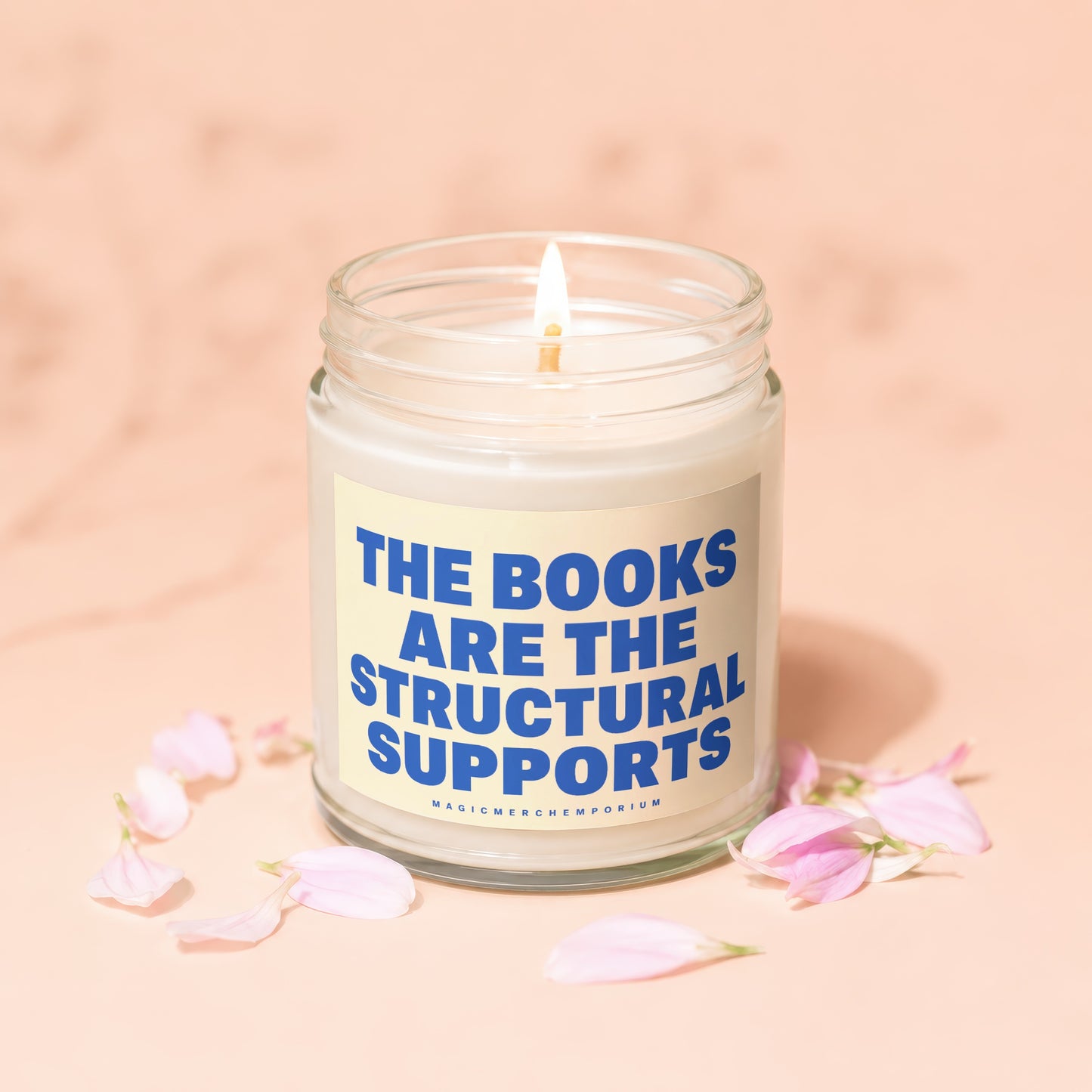 Glass candle with lit flame and blue text: "THE BOOKS ARE THE STRUCTURAL SUPPORTS".