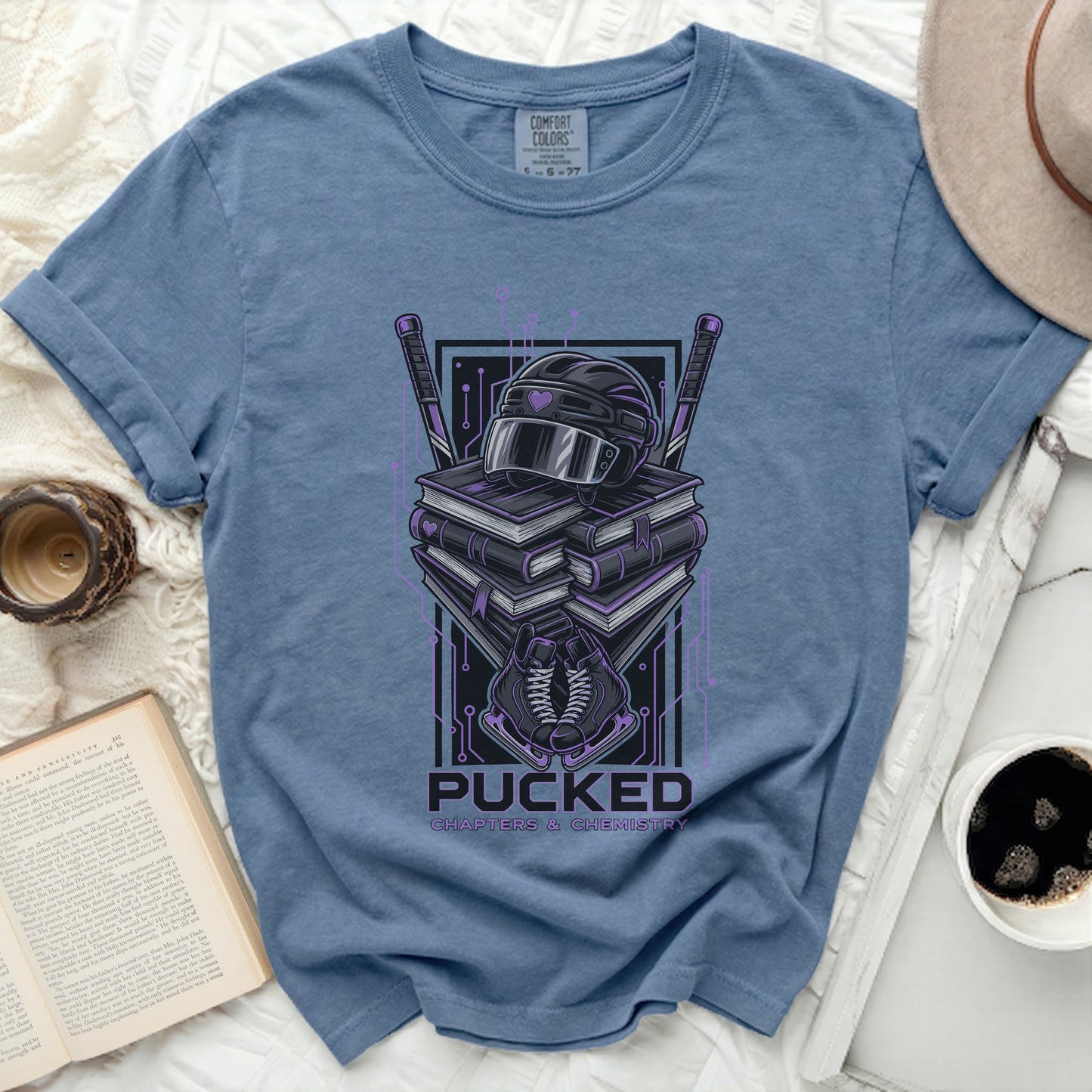Blue t-shirt with hockey gear and books graphic.