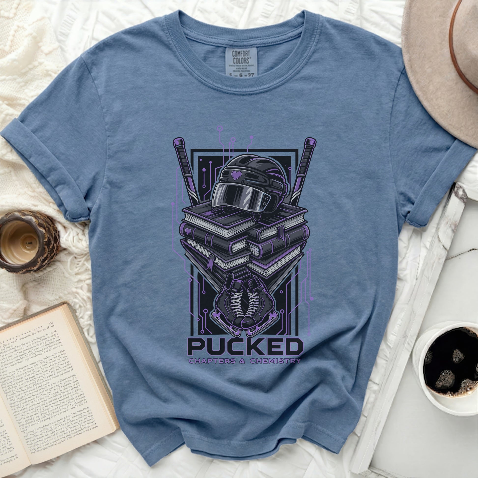 Blue t-shirt with hockey gear and books graphic.