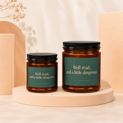 Two amber glass candles with dark lids, featuring green labels with white text.