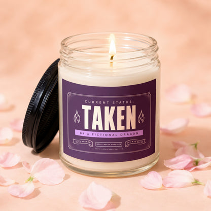 Soy wax candle labeled "Taken by a Fictional Dragon".