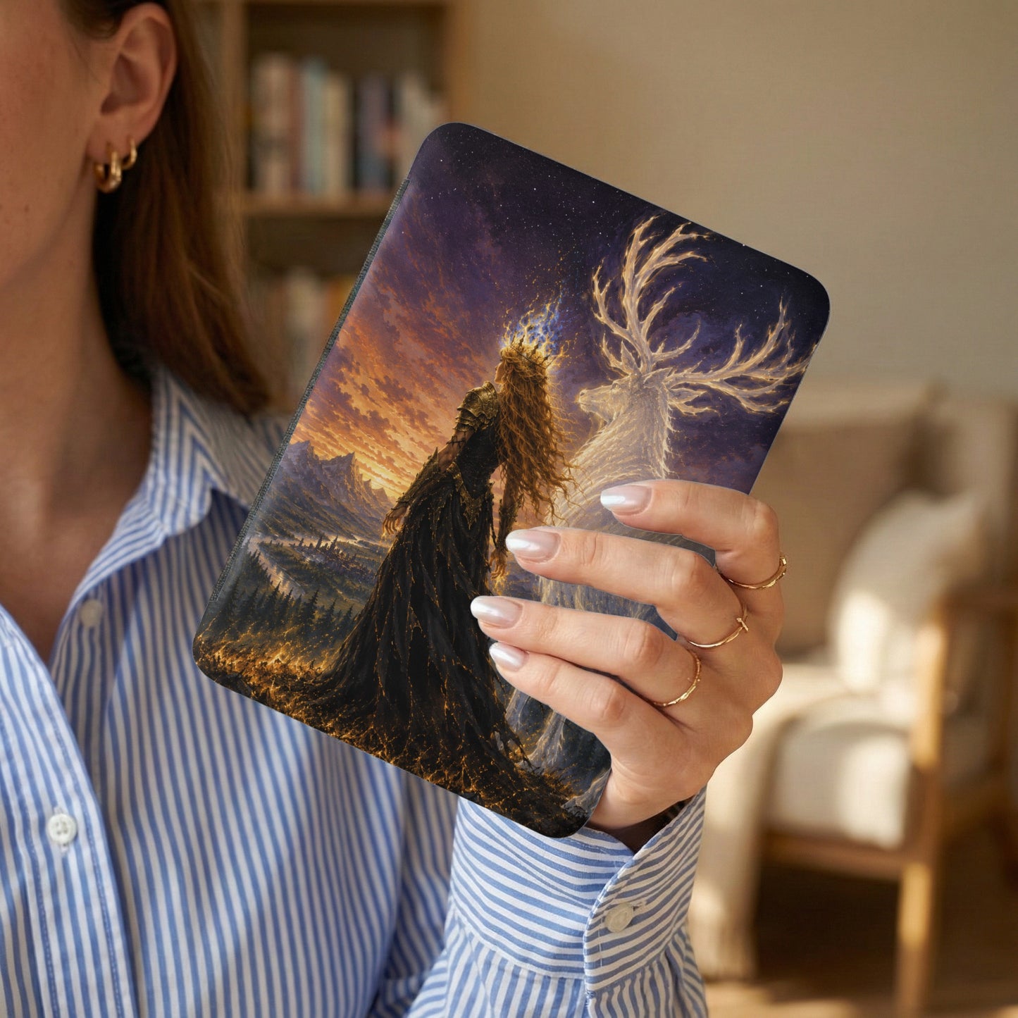 Digital artwork depicting a queen and stag against a mystical landscape, held by a person.