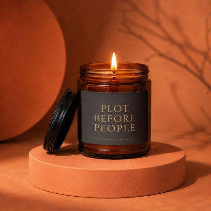 Amber jar candle with lit flame, reads "Plot Before People".