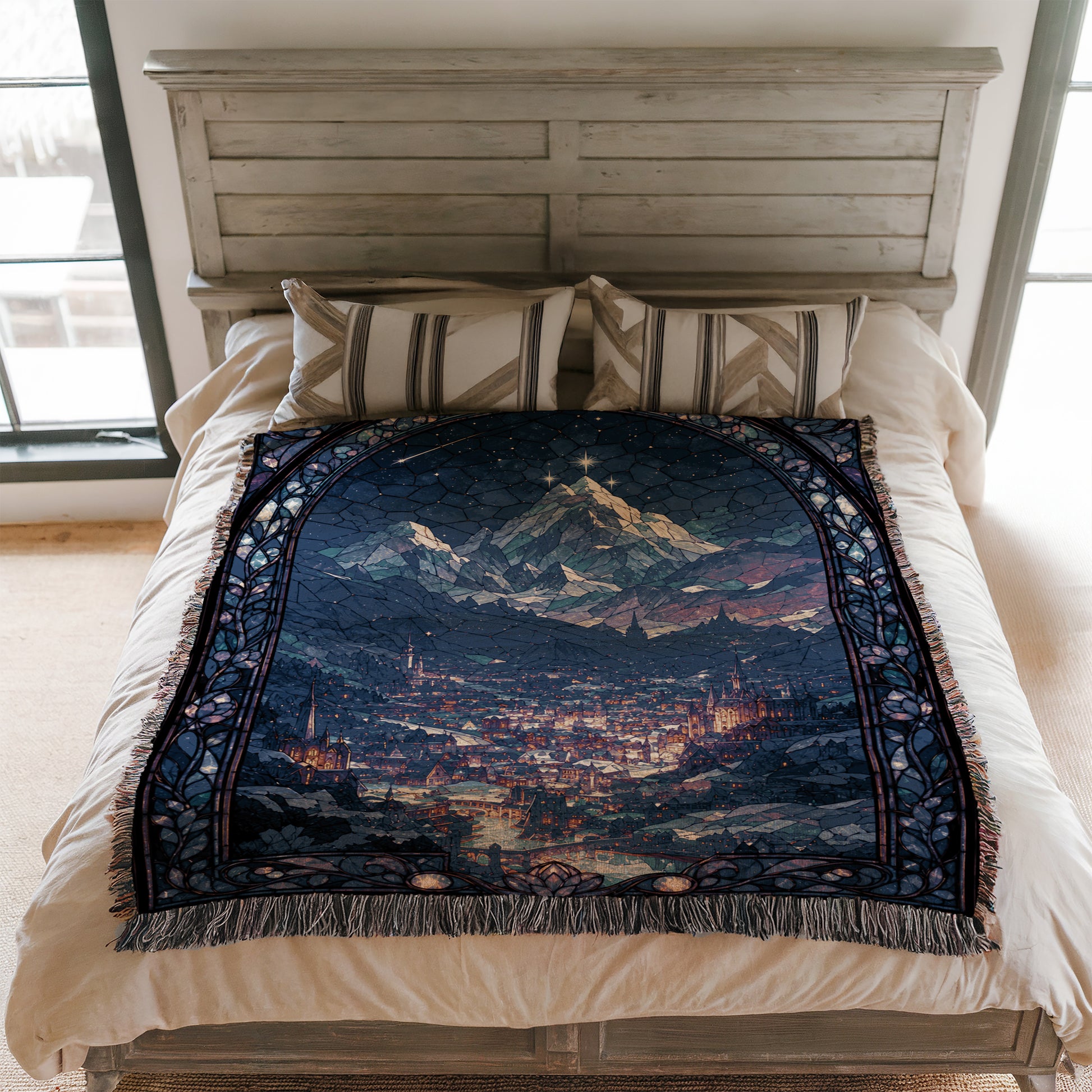 a bed with a large, colorful, and intricate tapestry or blanket covering it. The blanket features a detailed scene of a cityscape with mountains in the background, creating a visually striking and imaginative design.