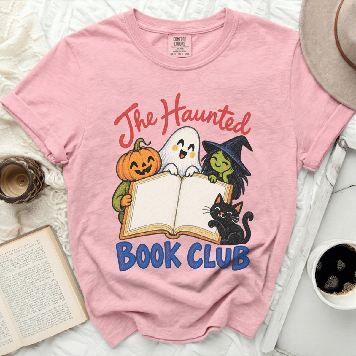 Pink t-shirt with "The Haunted Book Club" graphic featuring a pumpkin, ghost, witch, and cat.