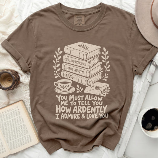 Brown t-shirt with stacked books, tea cup, and inscription "You Must Allow Me To Tell You How Ardently I Admire & Love You."
