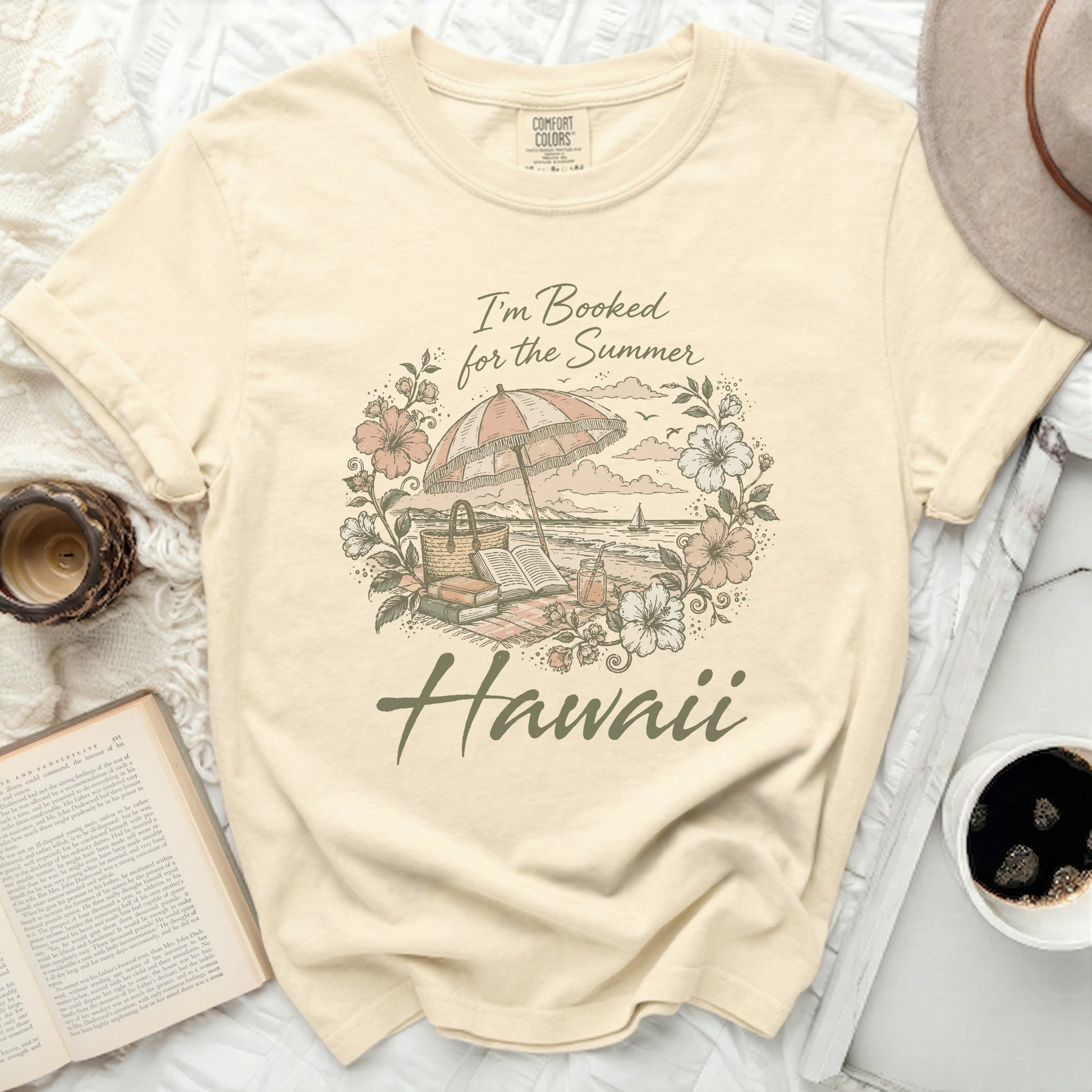 T-shirt with beach umbrella, book, and "Hawaii" text.