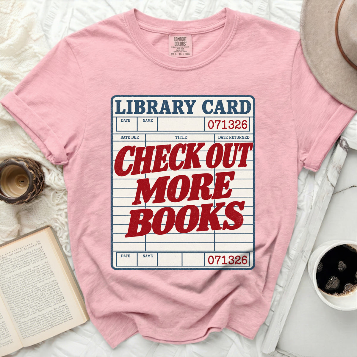 Pink t-shirt with "Library Card Check Out More Books" graphic design.