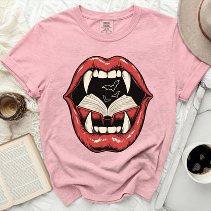 Pink t-shirt with graphic of open mouth, fangs, and open book with bats.