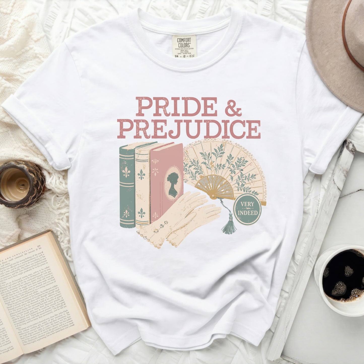 White t-shirt with "Pride & Prejudice" graphic featuring books, fan, and gloves.