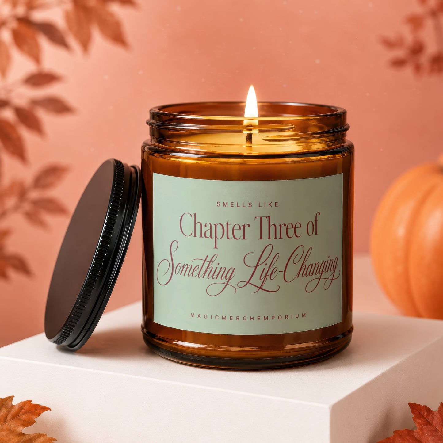 Amber glass candle with lit wick, label reads "Smells Like Chapter Three of Something Life-Changing".