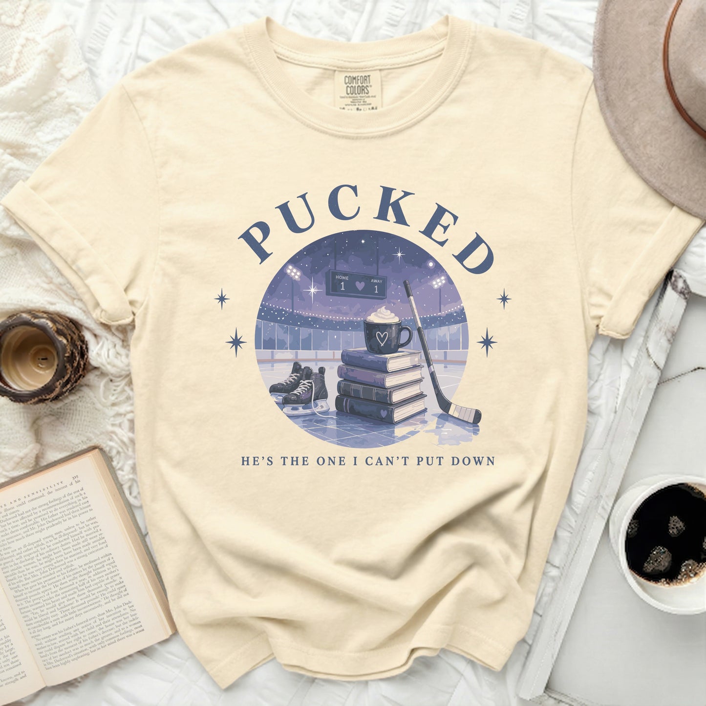 Cream t-shirt with "PUCKED" text and hockey graphic.