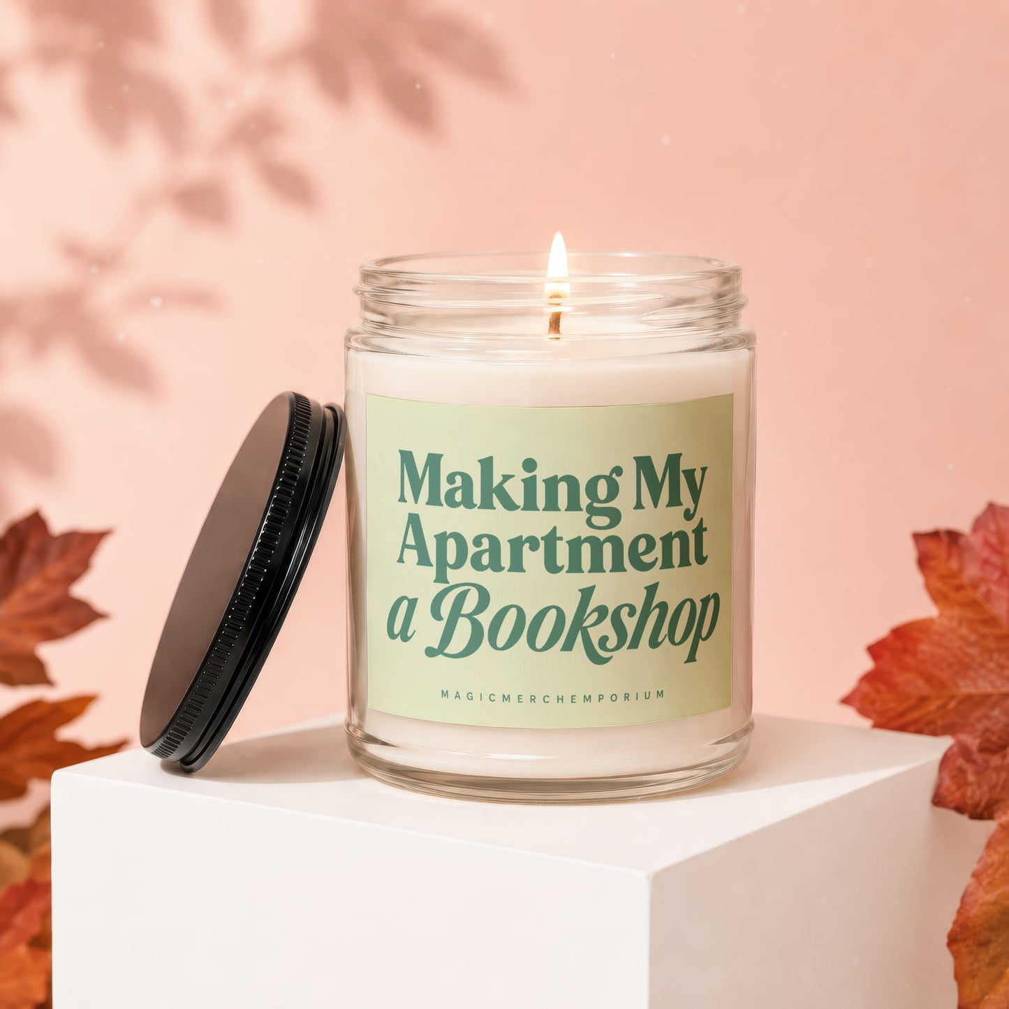 Glass jar candle with lit wick and text "Making My Apartment a Bookshop".