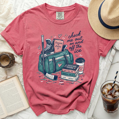 Pink t-shirt with ice hockey gear, books, and "check me out on and off the ice" text.