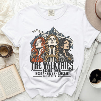 White t-shirt with "The Valkyries Rising Tour" graphic featuring three women and mountains.