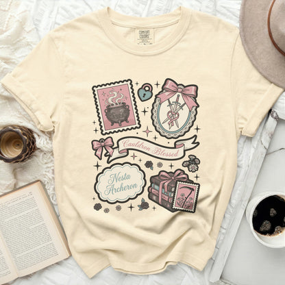 Cream t-shirt with vintage graphic art featuring a cauldron, swords, books, and text.