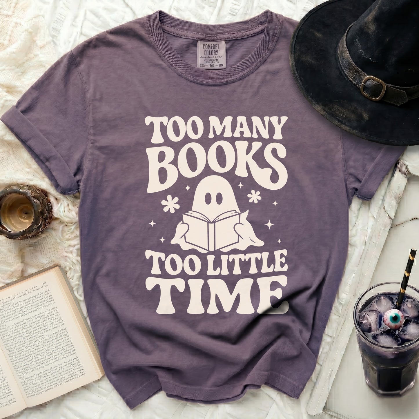 Purple t-shirt with ghost reading book and "Too Many Books Too Little Time" text.