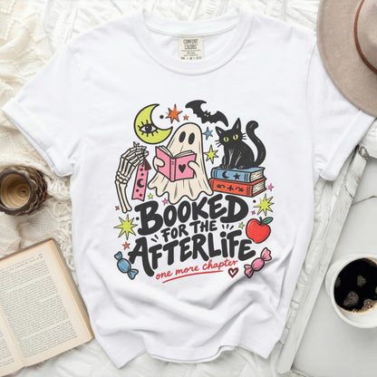 Ghost reading book with cat, moon, and bats, text "Booked for the afterlife"