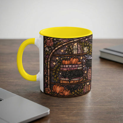 Mug with yellow handle featuring stained glass art of a black cat sleeping on books and pumpkins.
