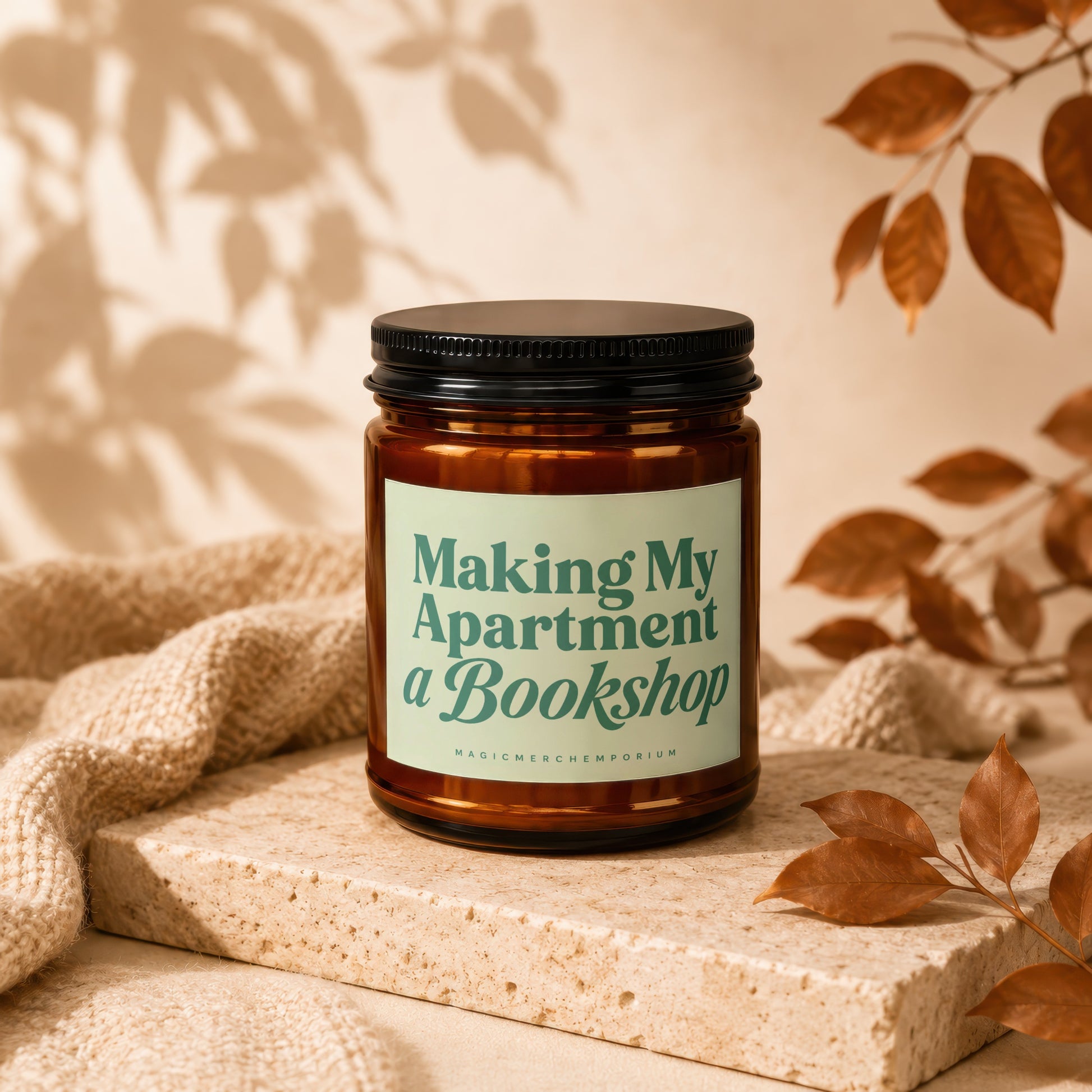 Amber candle with black lid, "Making My Apartment a Bookshop" text on label.