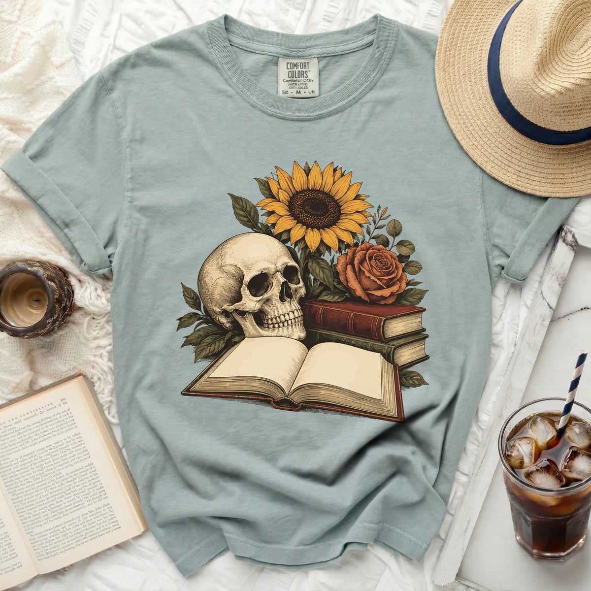 T-shirt with skull, sunflower, rose, and open book graphic.