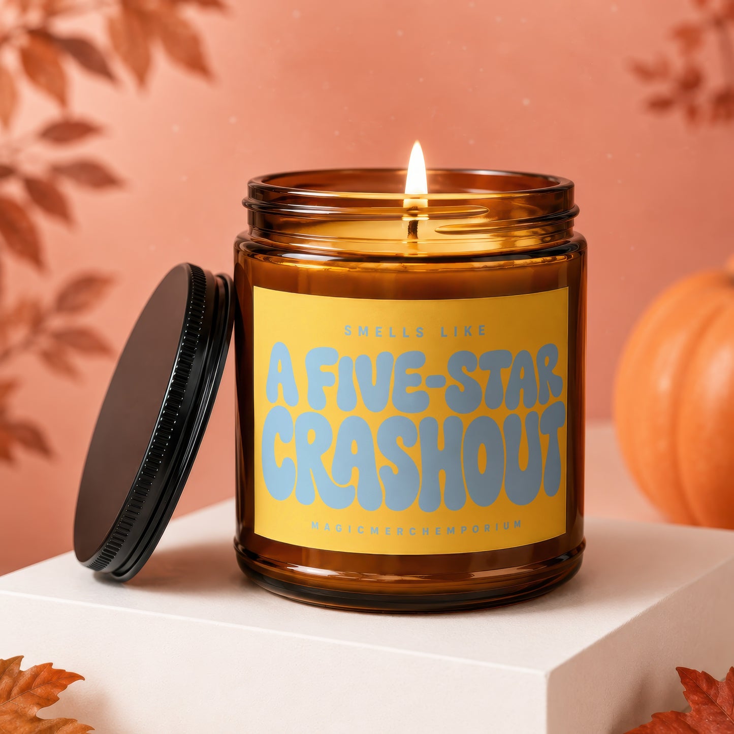 Lit amber glass candle with "Smells Like A Five-Star Crash Out" on yellow label.