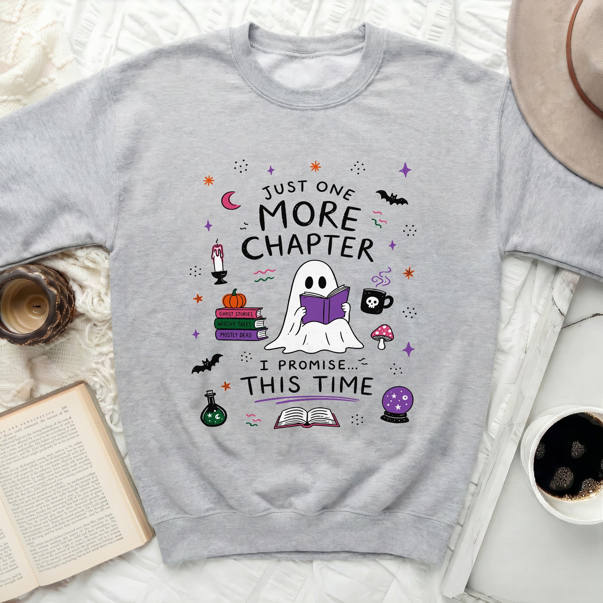 Grey sweatshirt with "Just One More Chapter" and a reading ghost design.