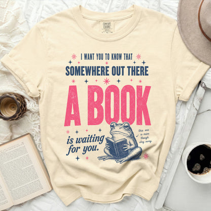 Cream t-shirt with frog reading a book and text "A BOOK is waiting for you."