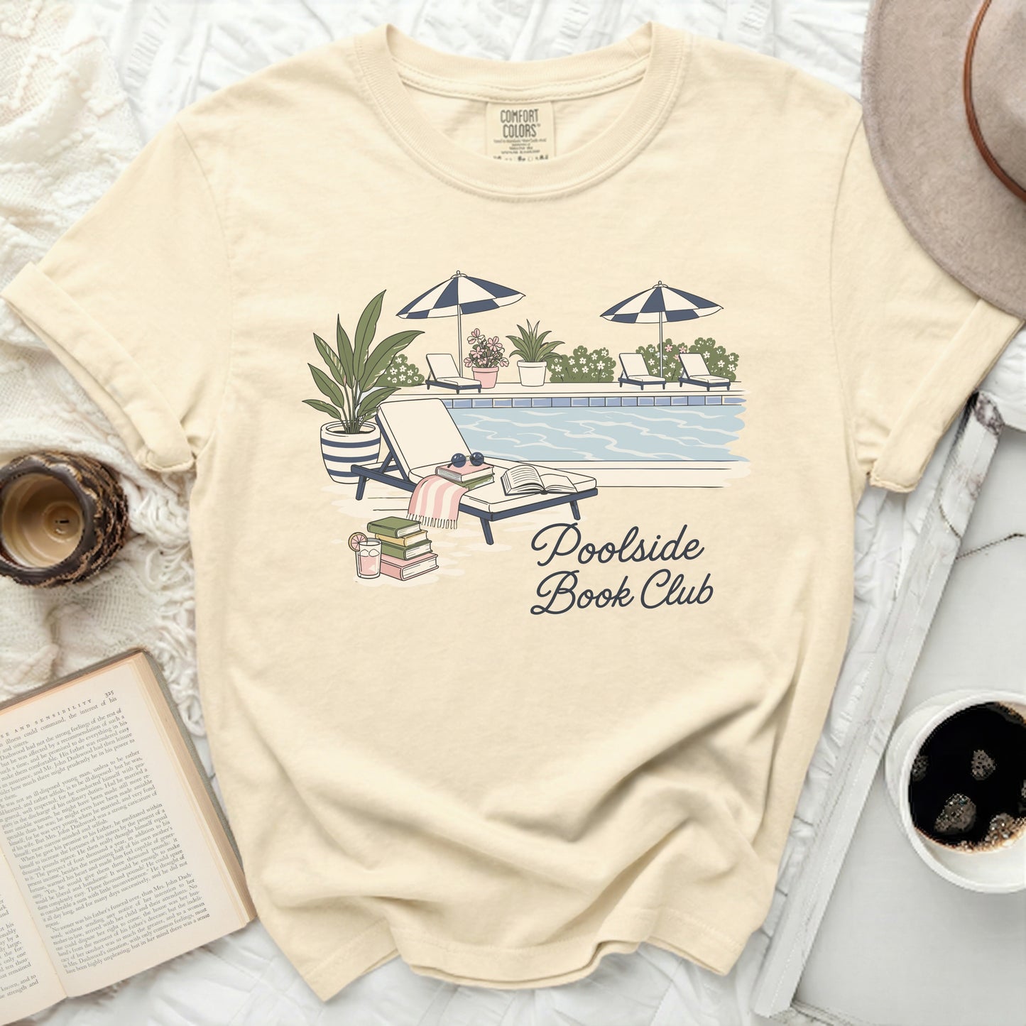 Cream t-shirt with "Poolside Book Club" graphic and pool scene.