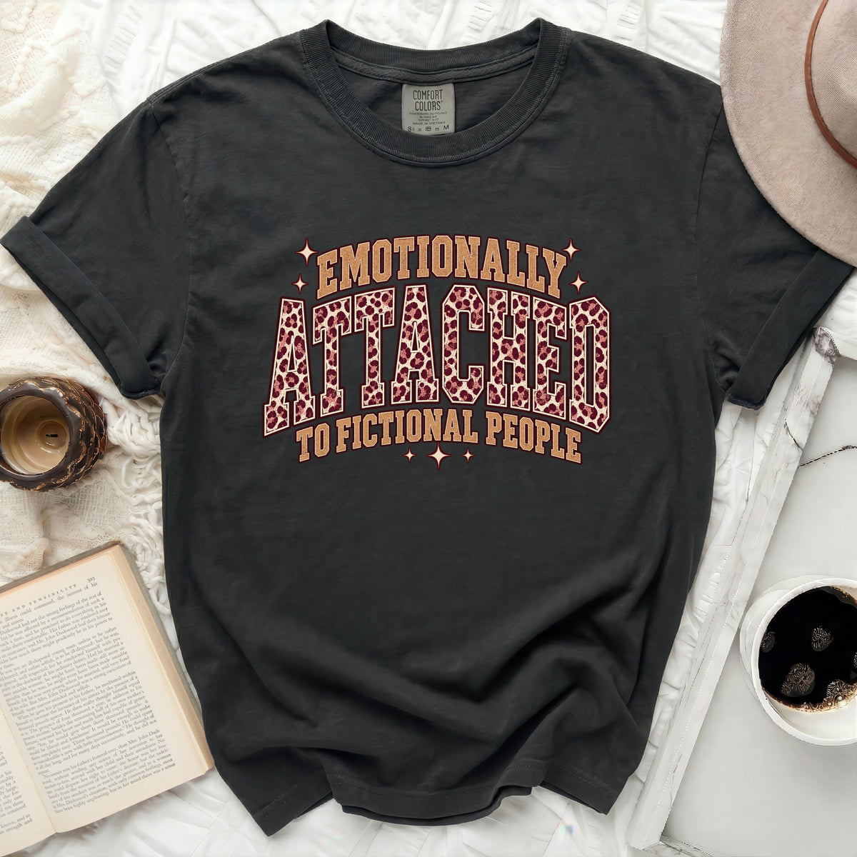 Dark t-shirt with "Emotionally Attached to Fictional People" graphic.