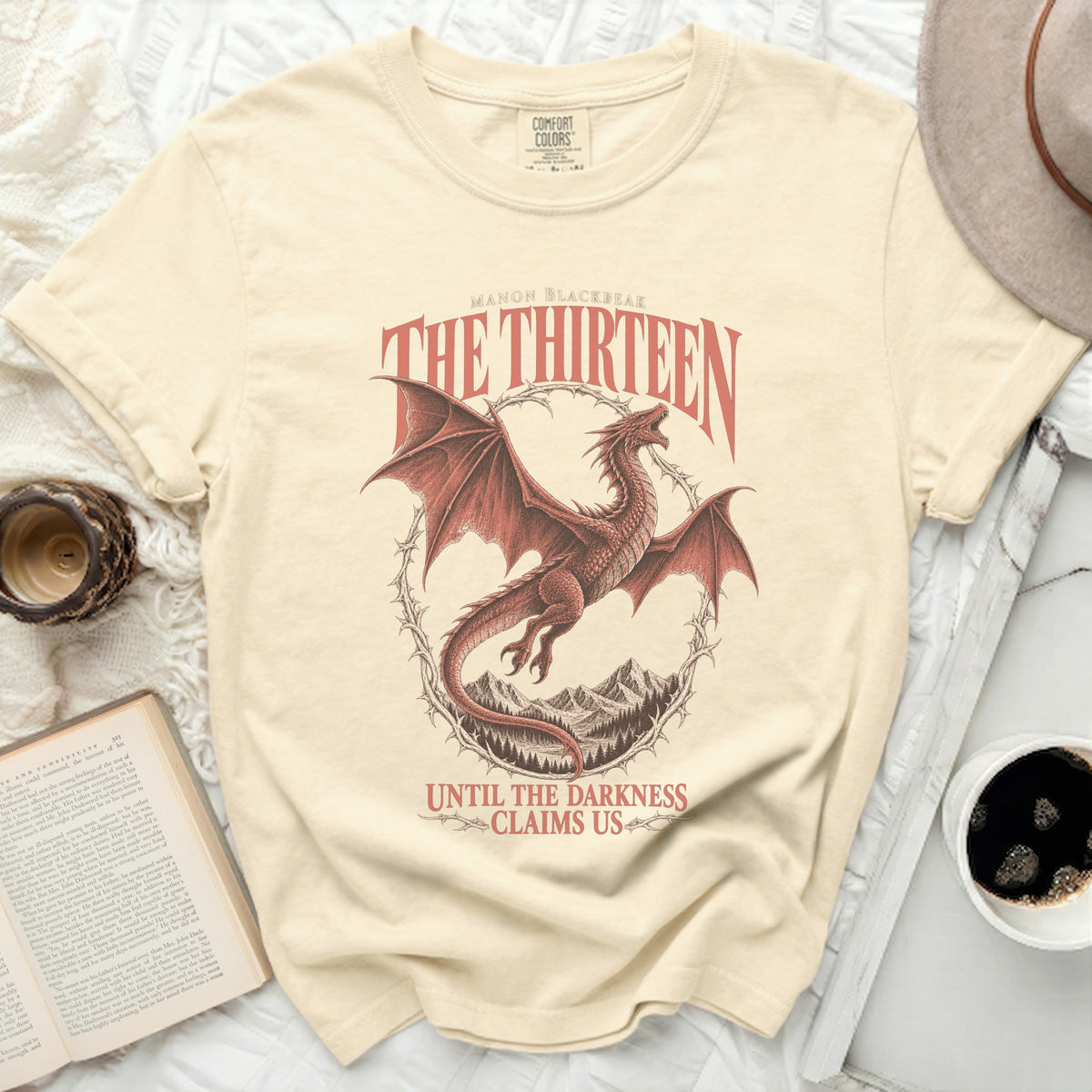 Cream t-shirt with red dragon graphic, "The Thirteen" and "Until the Darkness Claims Us" text.
