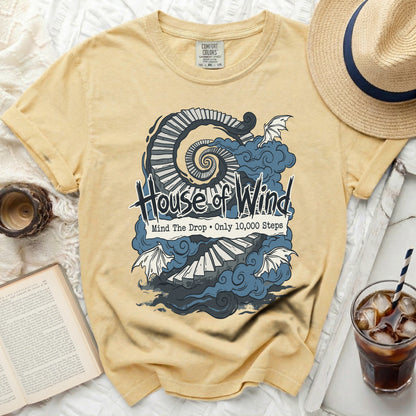 Yellow shirt with "House of Wind" and spiral staircase graphic.