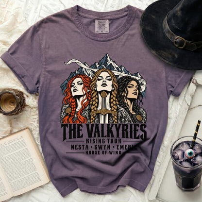Purple t-shirt with "The Valkyries Rising Tour" graphic featuring three women and mountains.
