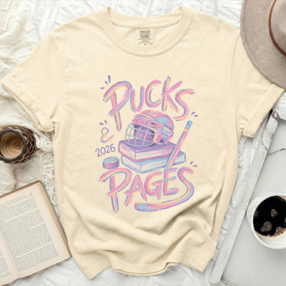 Cream t-shirt with "Pucks & 2026 Pages" text and hockey theme.
