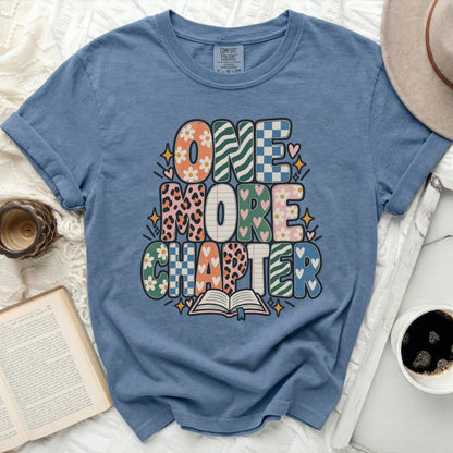 Blue t-shirt with "One More Chapter" text and an open book graphic.