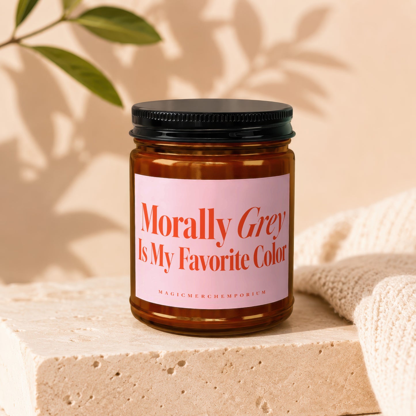 Amber jar candle with pink label reading "Morally Grey Is My Favorite Color".