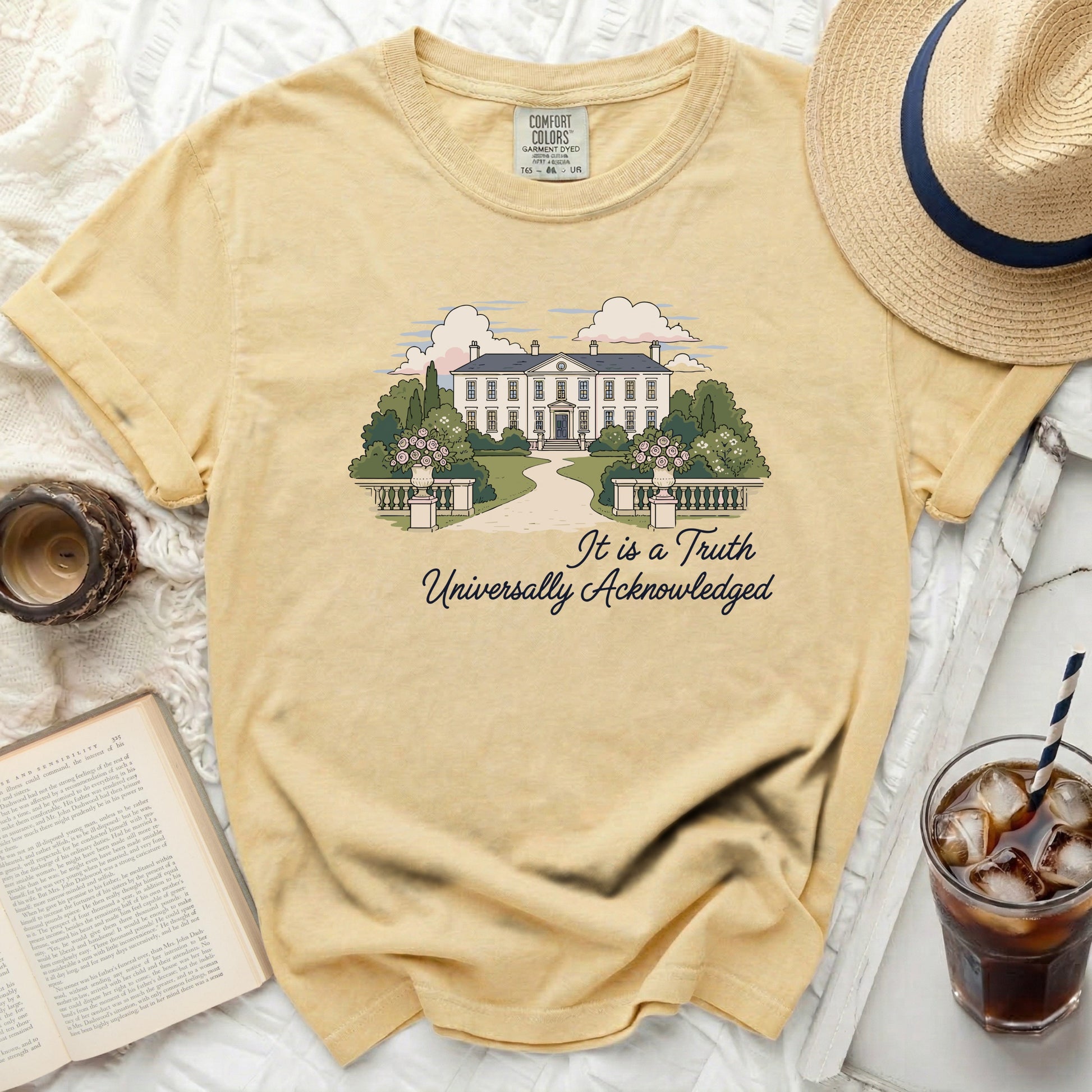 Yellow comfort colors t-shirt with illustration of a mansion and text "It is a Truth Universally Acknowledged".
