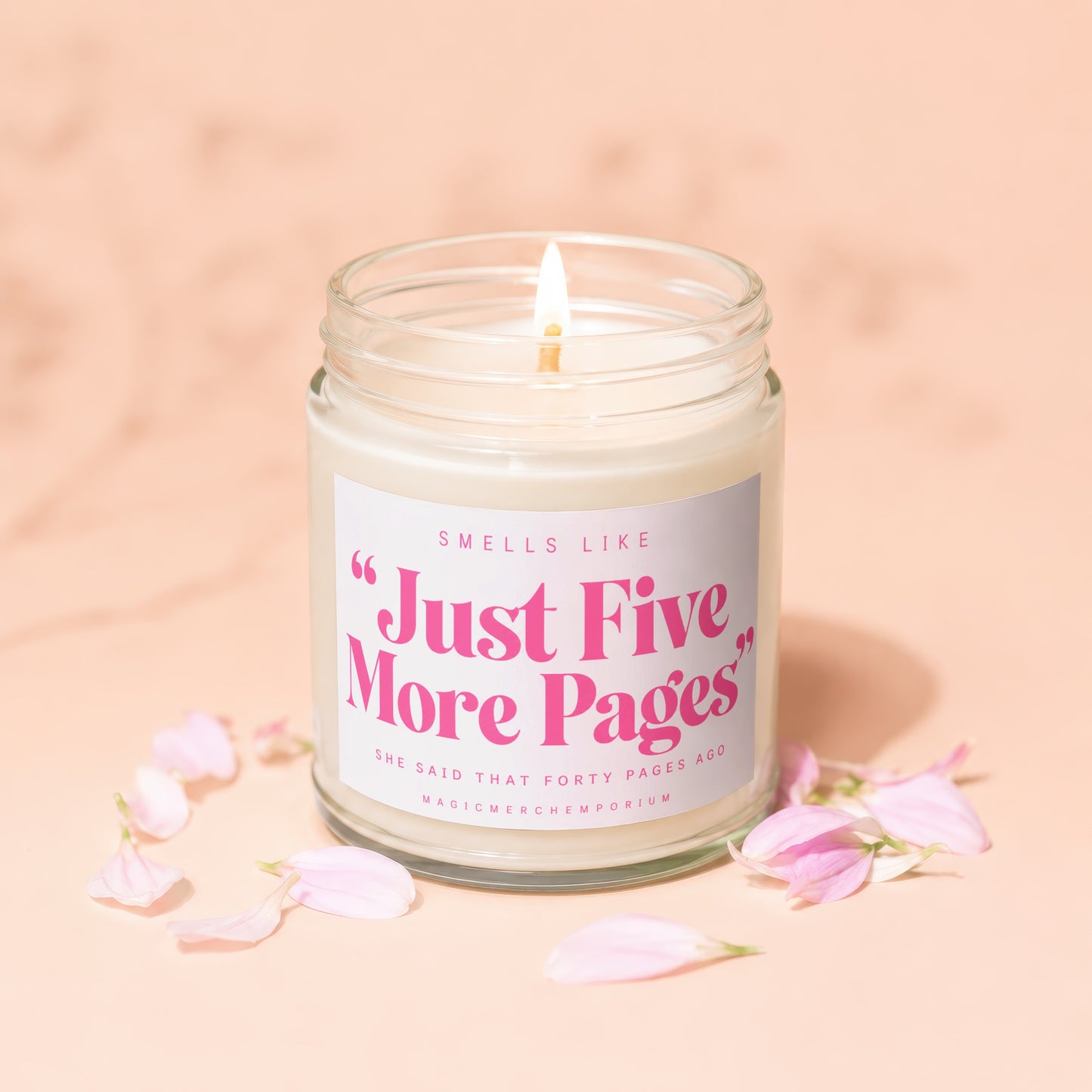 Scented candle with lit flame, featuring text "Just Five More Pages".