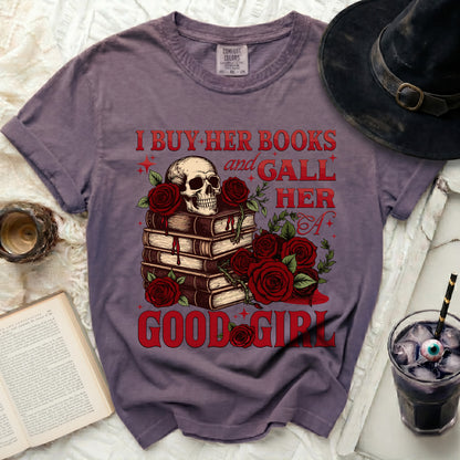 Purple t-shirt with skull, books, and roses graphic reading "I buy her books and gall her a good girl".