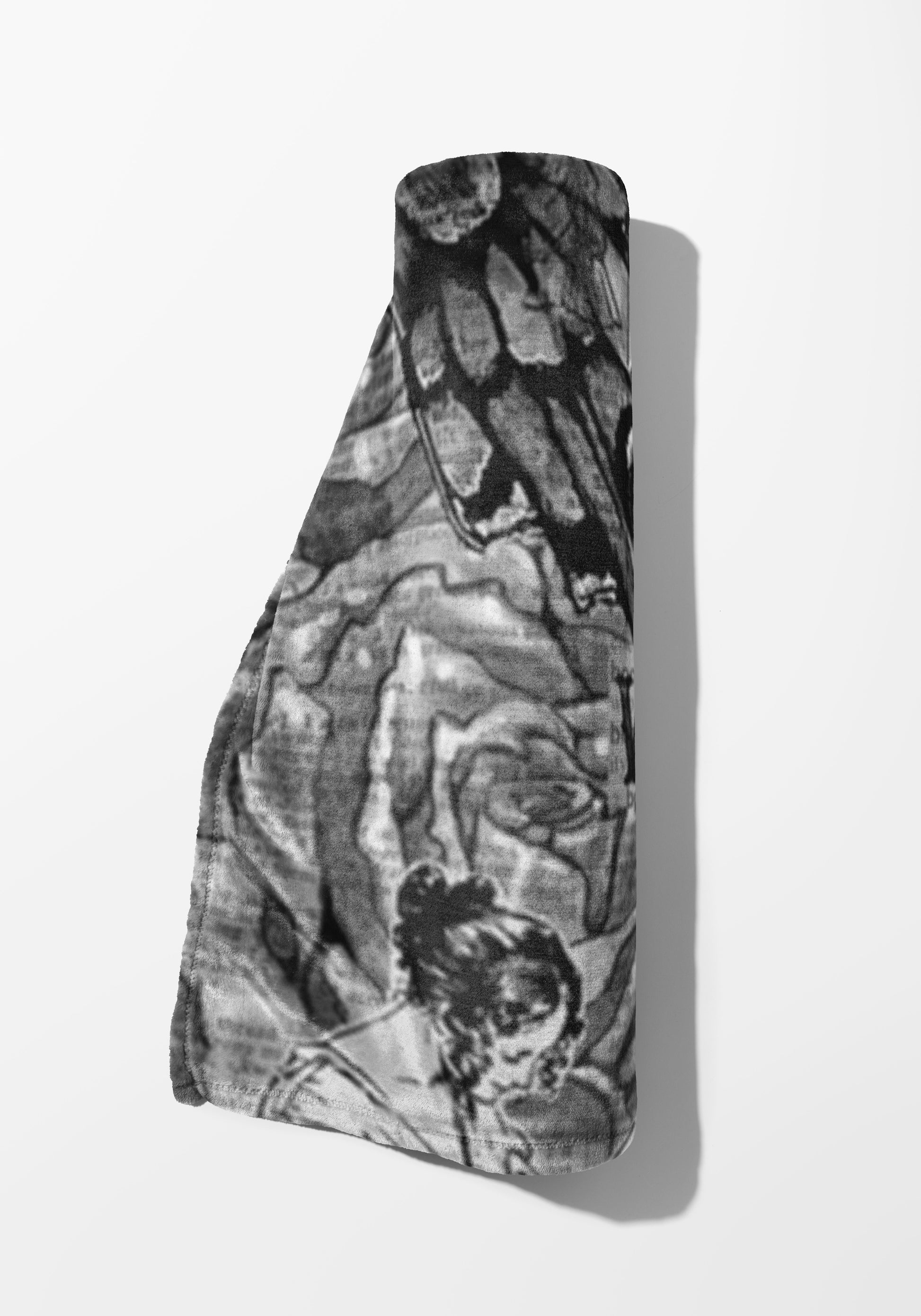Rolled blanket with black and white abstract pattern and draped edges.
