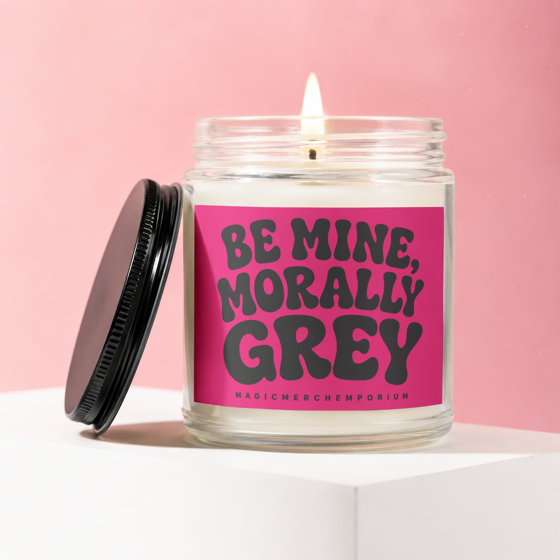Jar candle with pink label that reads "BE MINE, MORALLY GREY" and "MAGICMERCHEMPORIUM".