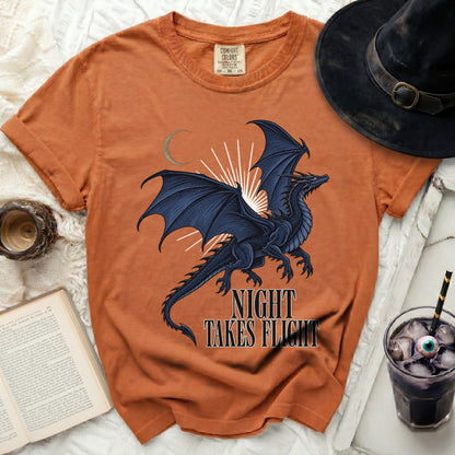 Orange t-shirt with black dragon graphic and "Night Takes Flight" text.