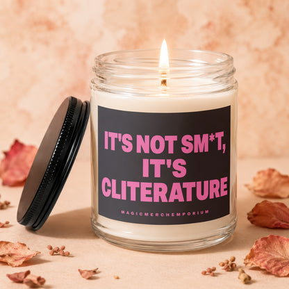 Candle with lit wick and black label reading "IT'S NOT SM*T, IT'S CLITERATURE".